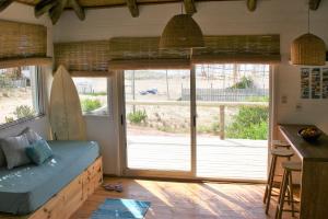 un soggiorno con una grande porta scorrevole in vetro di Cabaña PRAIA a Punta Del Diablo Altre 14 foto