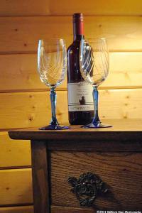 a bottle of wine and two wine glasses on a table at Los Gatos Bed & Breakfast in Penn Yan