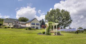 a house with a large yard with a solarium at Los Gatos Bed & Breakfast in Penn Yan