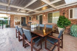 an outdoor patio with a wooden table and chairs at Colonial Court House in Mudgee