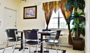 a table and chairs in a room with a window at Scottish Inn and Suites Alvin in Alvin