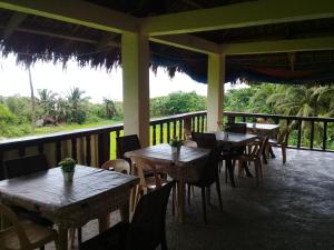 um restaurante com mesas e cadeiras numa varanda em JoSurfInn, Puraran Beach em Baras