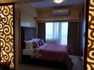 Säng eller sängar i ett rum på Elizabeth 1830 @ Wind Residences