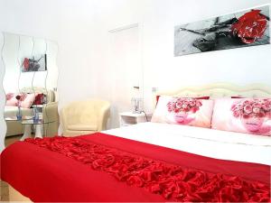 a bedroom with a red bed with roses on it at B&B Vanessa House in Martellago