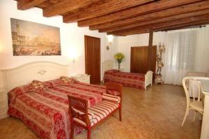 1 dormitorio con 2 camas, mesa y sillas en Ca' Dei Leoni, en Venecia