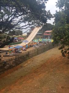 a large slide in a pool with tables and chairs at Beach frond apartment in Amanzimtoti
