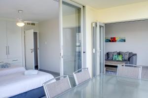 een slaapkamer met een bed en stoelen en een glazen vloer bij 14 Kyalanga - by Stay in Umhlanga in Durban