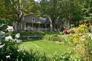 a house with a yard with flowers at West Hill House B&B in Mad River Valley in Warren
