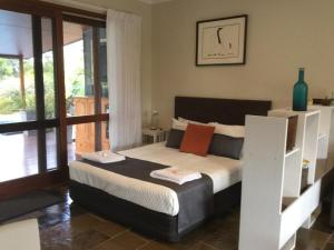 a bedroom with a bed and a balcony at The Croft Bed and Breakfast in Murwillumbah
