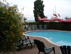 a swimming pool with chairs and a table at Confederation Place Hotel in Kingston