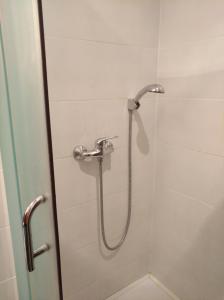 y baño con ducha con cabezal de ducha. en Hostel Lux, en Kaunas