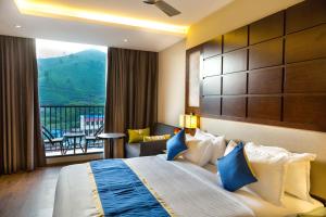 a hotel room with a bed and a balcony at Casa Montana Munnar in Munnar