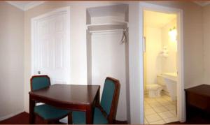 a dining room with a table and chairs and a bathroom at Sunset Inn and Suites West Sacramento in West Sacramento