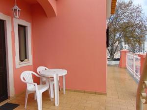 a white table and two chairs on a patio at Saraiva's Guest House in Lagos