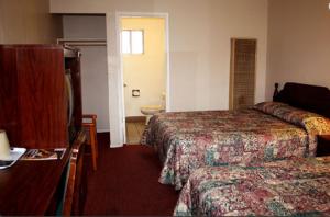 Habitación de hotel con 2 camas y lavamanos en Sunset Inn and Suites West Sacramento, en West Sacramento