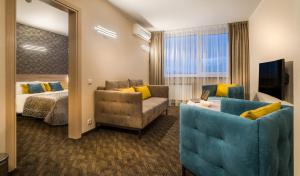 una camera d'albergo con letto, divano e specchio di Hotel Zemaites a Vilnius