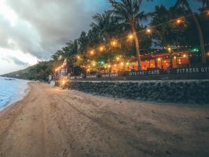 a beach at night with street lights and a building at Coral Resort & Bungalows in Haad Rin +92 photos
