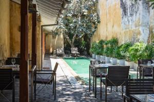 an outdoor restaurant with a pool and tables and chairs at The Fort Printers in Galle