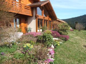 a house with a bunch of flowers in front of it at B&B Chalet l'Epinette in Gérardmer