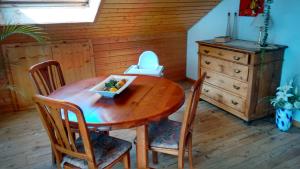 een houten tafel met stoelen en een fruitschaal erop bij Ferienwohnung Munz in Ringsheim