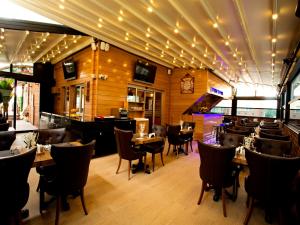 ein Restaurant mit Holzwänden, Tischen und Stühlen in der Unterkunft Endglory Hotel in Çorlu