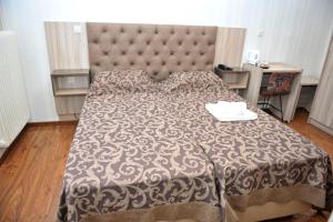 a bedroom with a large bed with a large headboard at Hotel Vergina in Alexandroupoli