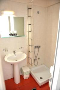 y baño con lavabo y ducha. en Hotel Vergina en Alejandrópolis