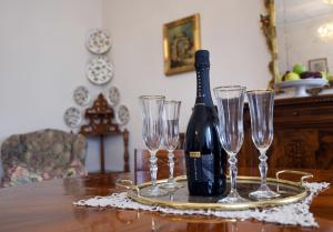 een fles wijn en vier wijnglazen op een tafel bij Residenza Ca Trinità in Venetië