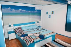 um quarto com uma cama com uma pintura do oceano em Sailors Guest House Jurilovca em Jurilovca