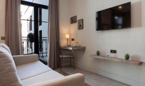 salon z kanapą i telewizorem na ścianie w obiekcie Hotel Diana w Tossa de Mar