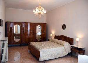 een slaapkamer met een bed en een kroonluchter bij Residenza Ca Trinità in Venetië