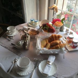 a table with a breakfast of bread and croissants at La Bergerie des Anges in Le Bignon-Mirabeau