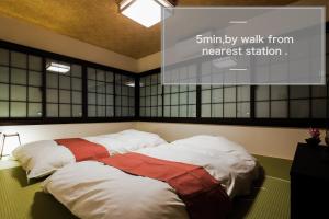dwa łóżka w pokoju z ekranem projekcyjnym w obiekcie Kyonomachi Hakuho w mieście Kioto