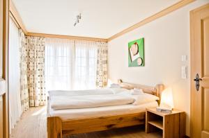 a bedroom with a large bed and a window at Chalet Princess - GRIWA RENT AG in Grindelwald