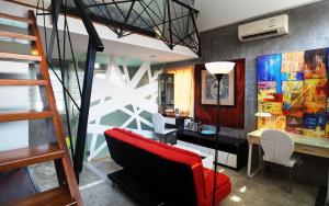 Cette chambre mansardée comprend un bureau et une chaise rouge. dans l'établissement Phuket Paradiso, à Chalong
