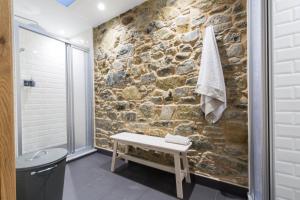 a bathroom with a stone wall at Albergue O Candil in Melide