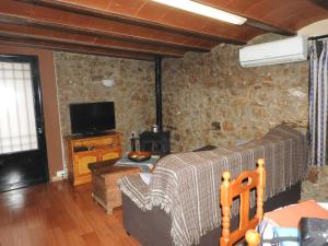 sala de estar con sofá y TV en Ca les bessones, en Villar de Canes