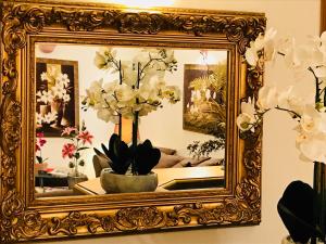 a gold picture frame with a vase of flowers at Hotel Le Festival in Cannes
