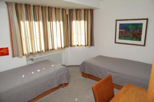 オーベルストドルフにあるFerienwohnung Fröhlkeのベッドルーム1室(ベッド2台、テーブル、窓付)