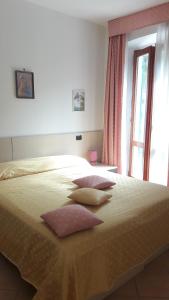 Un dormitorio con una cama grande con almohadas. en Affittacamere B&B Trattoria della Posta, en Maissana
