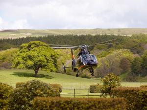 un helicóptero volando sobre un campo con un árbol en The Devonshire Arms Hotel & Spa - Skipton, en Bolton Abbey