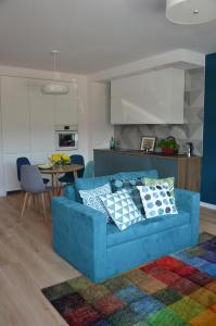 niebieska kanapa w salonie z kuchnią w obiekcie Apartament Pruszków w Pruszkowie