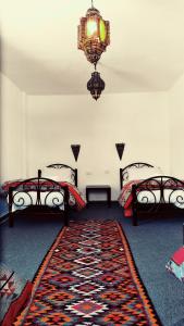 a room with two beds and a rug at Petra Bedouin Bed and Breakfast in Wadi Musa