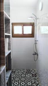 a bathroom with a shower and a black and white tile floor at Petra Bedouin Bed and Breakfast in Wadi Musa