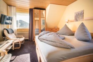een slaapkamer met een bed met kussens erop bij Haus Quentin in Willingen