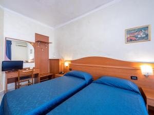 um quarto de hotel com uma cama azul e uma secretária em Hotel Aurora em Milão