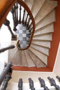 a spiral staircase in a building with a mirror at Egli Hotel in Andros