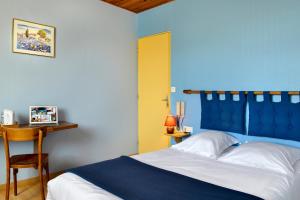 niebieska sypialnia z łóżkiem i żółtymi drzwiami w obiekcie Berry Relais w mieście Neuvy-Pailloux
