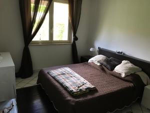 Schlafzimmer mit einem Bett, einem Fenster und einer Decke in der Unterkunft Casa Svetlana in Stalettì