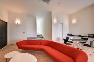 un sofá rojo en una sala de estar con mesas y sillas en Hotel 498, en Incheon